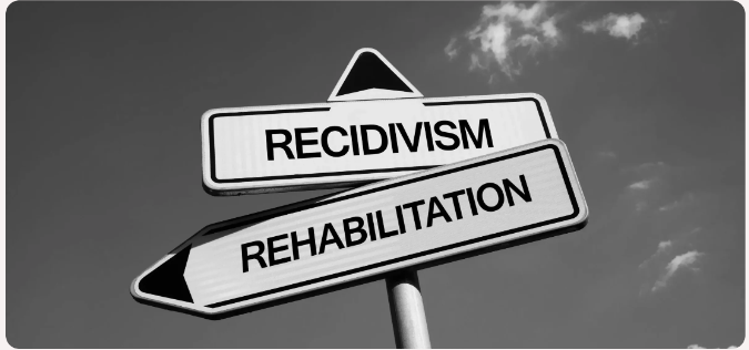 Directional signs reading recidivism and rehabilitation